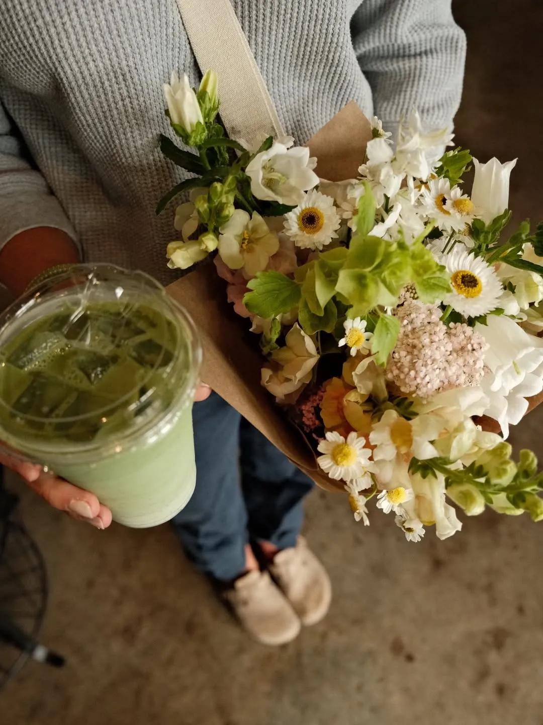 An iced drink beside a bouquet of fresh flowers