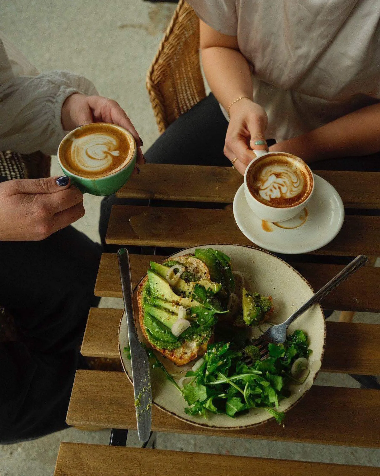 Two friends sharing latte art and avocado toast at Cafe Amarti